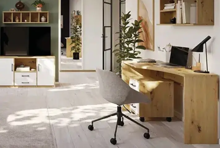 Holzschreibtisch mit Laptop, Lampe und grauem Drehstuhl, rechts Regalwürfel, links Lowboard mit Fernseher und Bücherregal, auf dem Boden heller Holzfussboden.